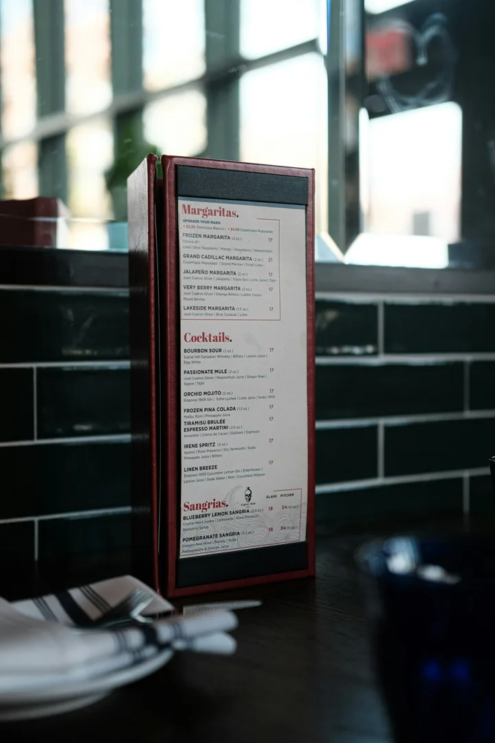 A printed restaurant drinks menu standing on a dining table