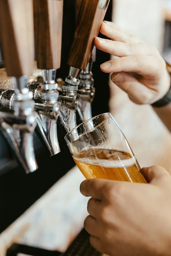 Bartender pulling a tap to pour a glass of beer