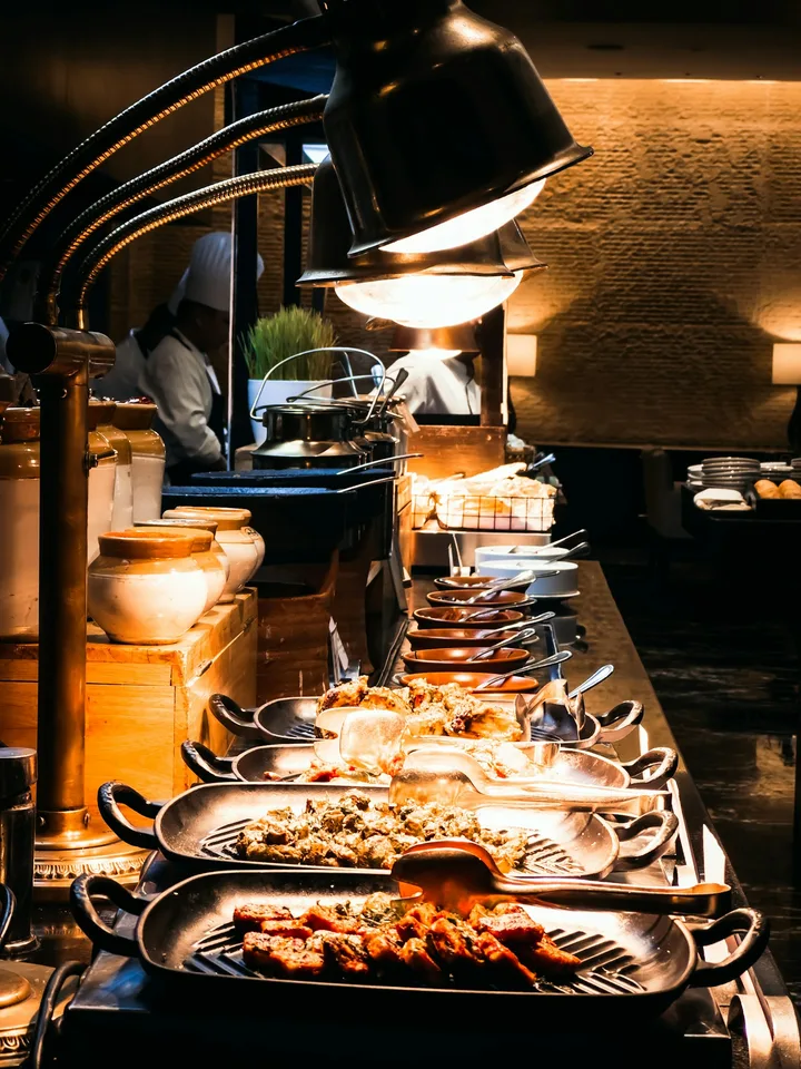Buffet line of hot dishes under heat lamps