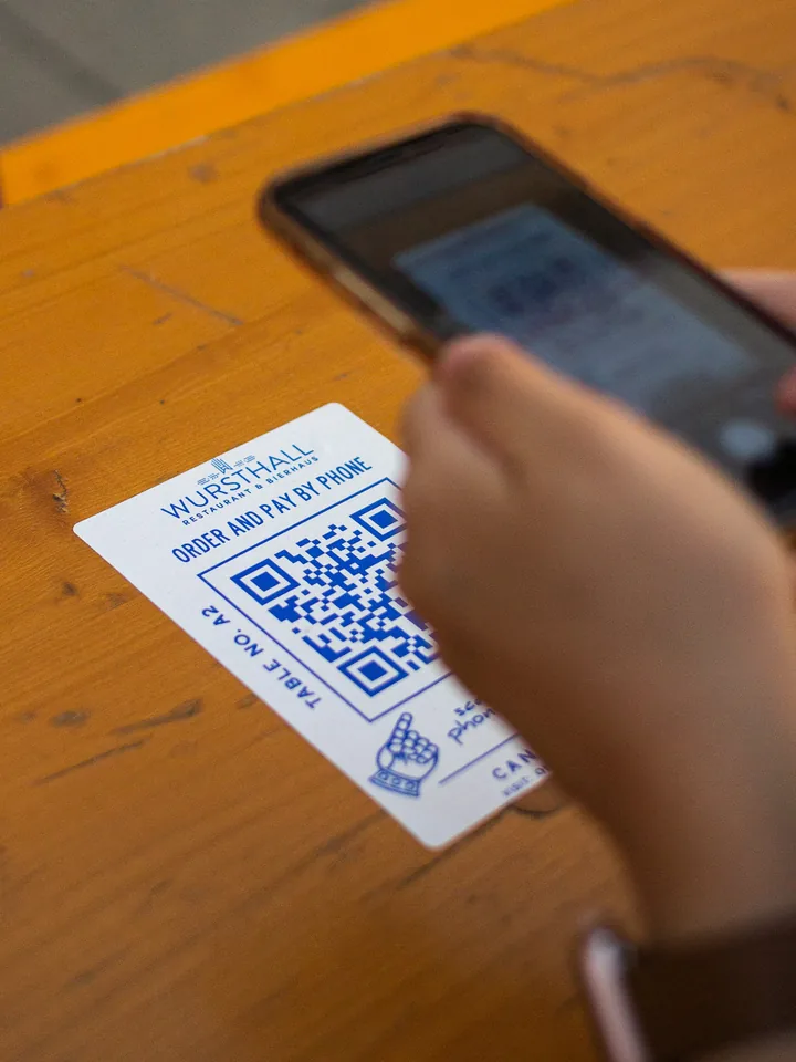 Guest scanning a QR code card at a restaurant table