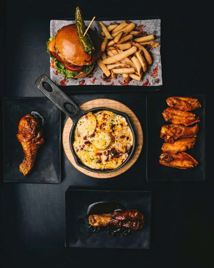 Overhead view of a burger, fries, wings and other dishes arranged for a menu photograph