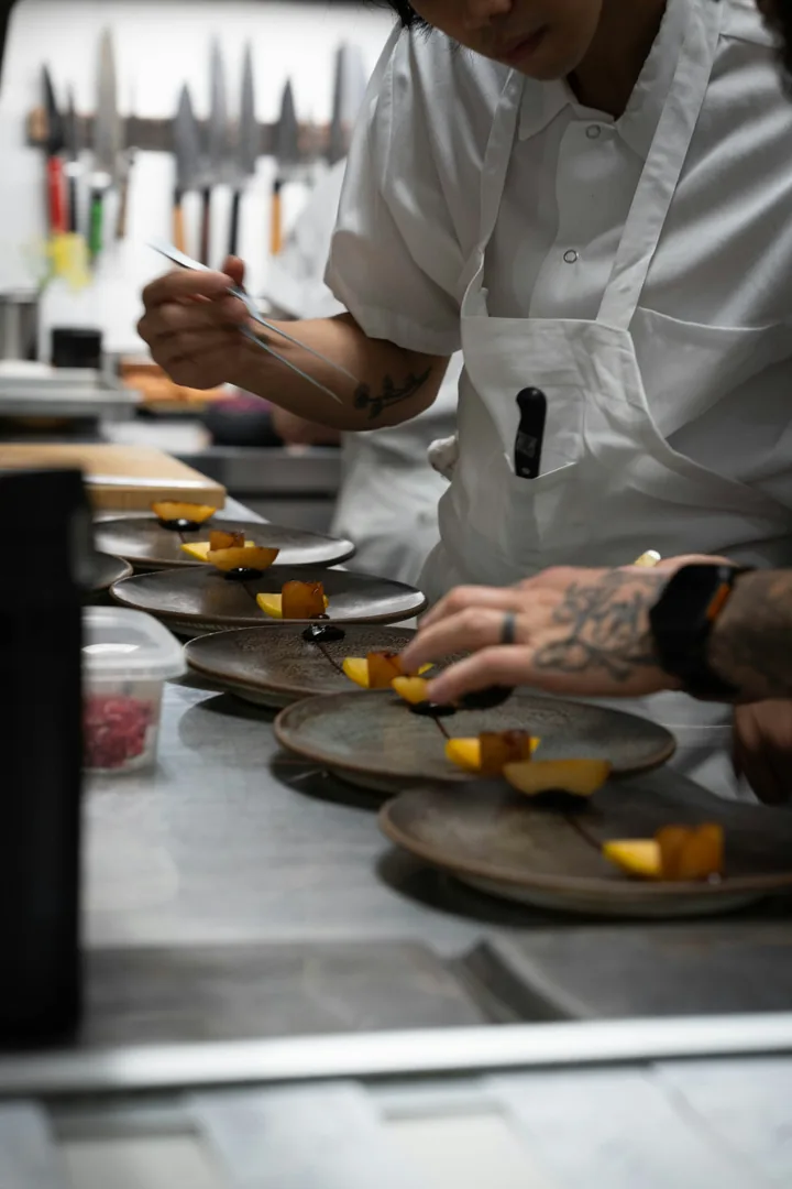 Chef plating several dishes in a restaurant kitchen