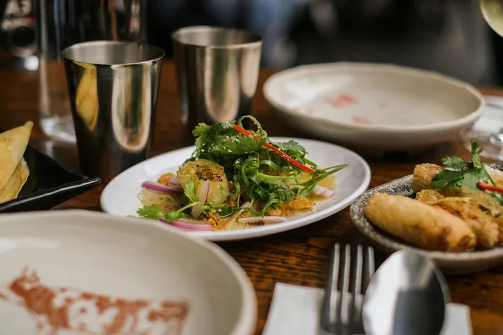 A restaurant table set with several plated dishes