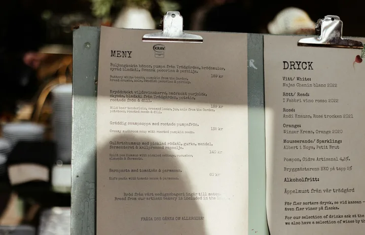 Printed food and drinks menus clipped to boards side by side